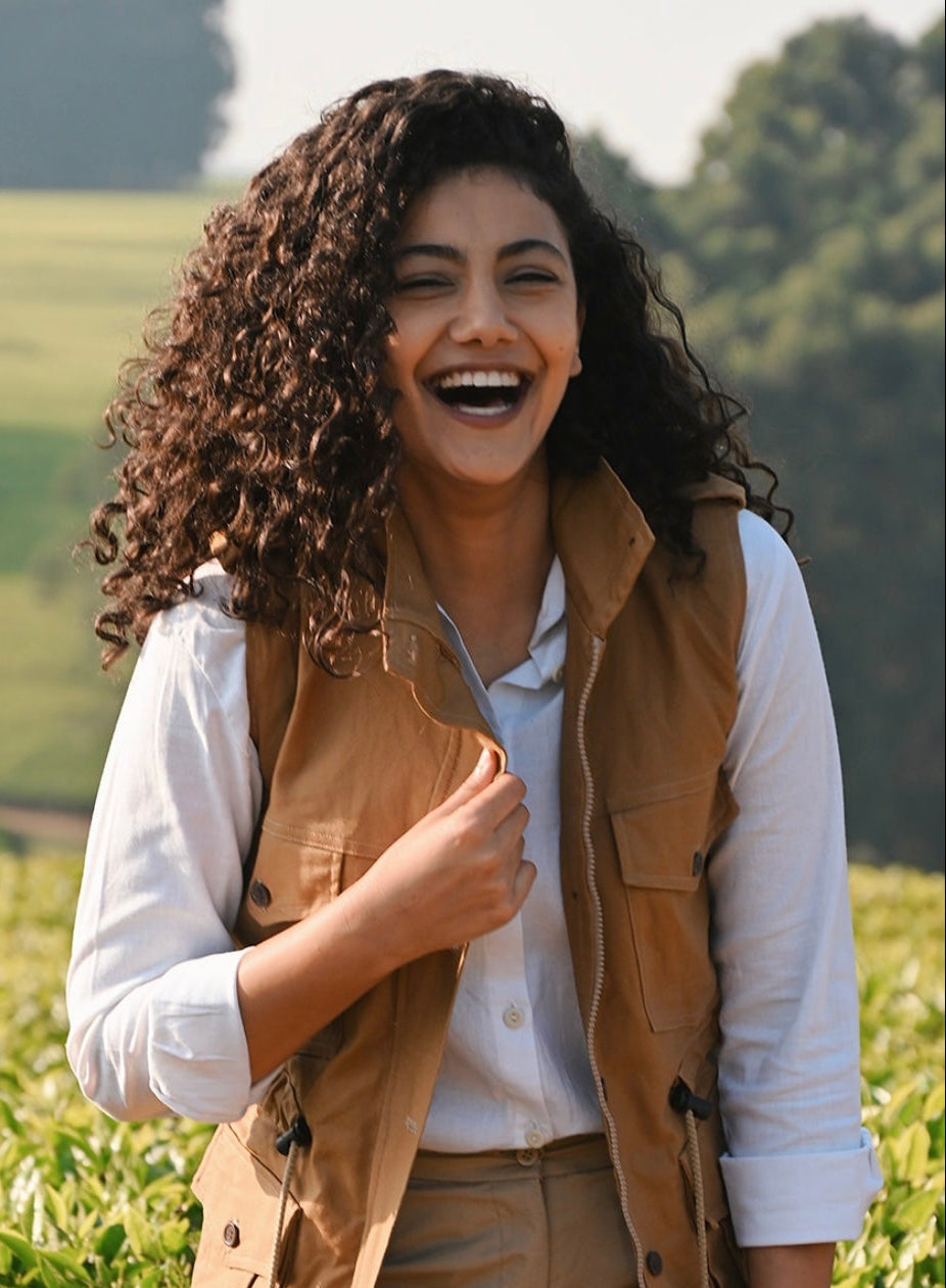 Woman laughing in a field with a natural background