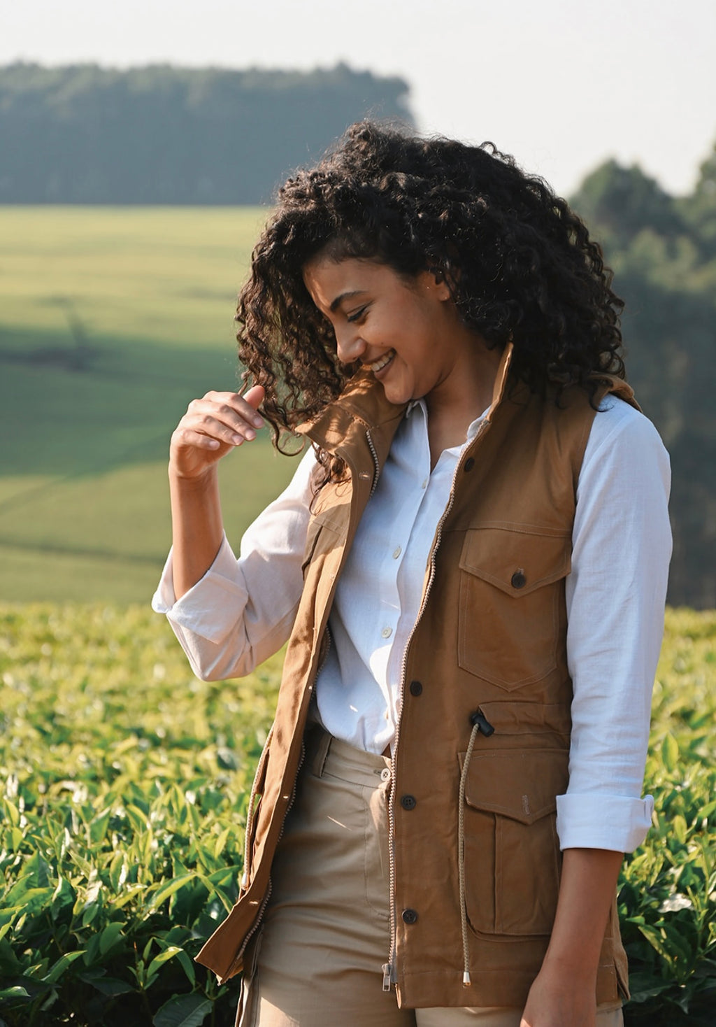 Woman in a brown vest standing in a field